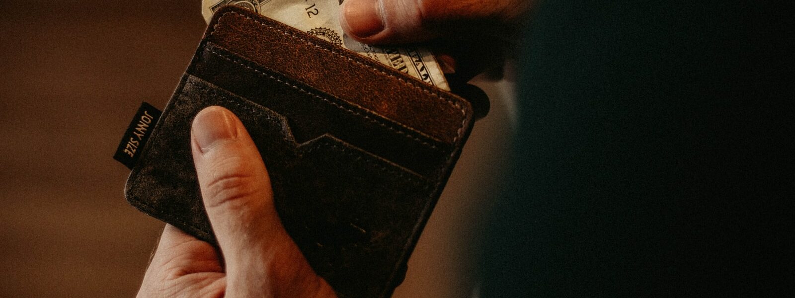 person getting 1 U.S. dollar banknote in wallet