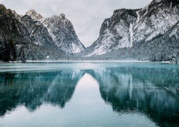 body of water and snow-covered mountains during daytime