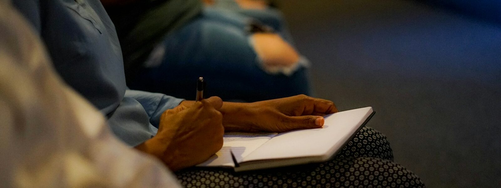 person holding pen and white paper on person lap
